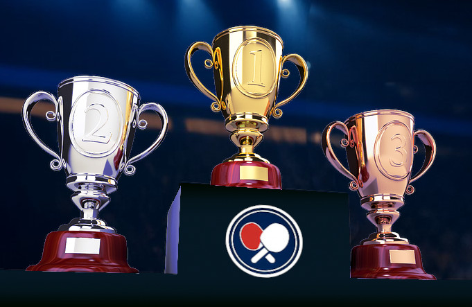 Gold, silver and bronze trophies sitting on a podium inside an arena